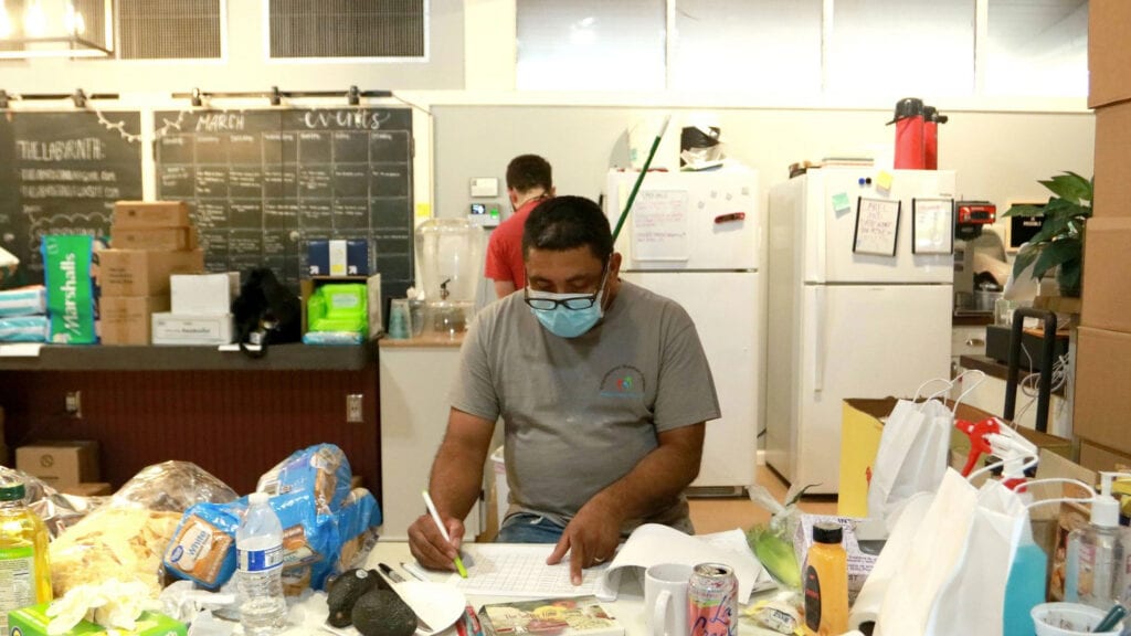 Mario Mendoza, a co-founder of a free food delivery program in New Orleans, reviews a delivery list in mid-April.
