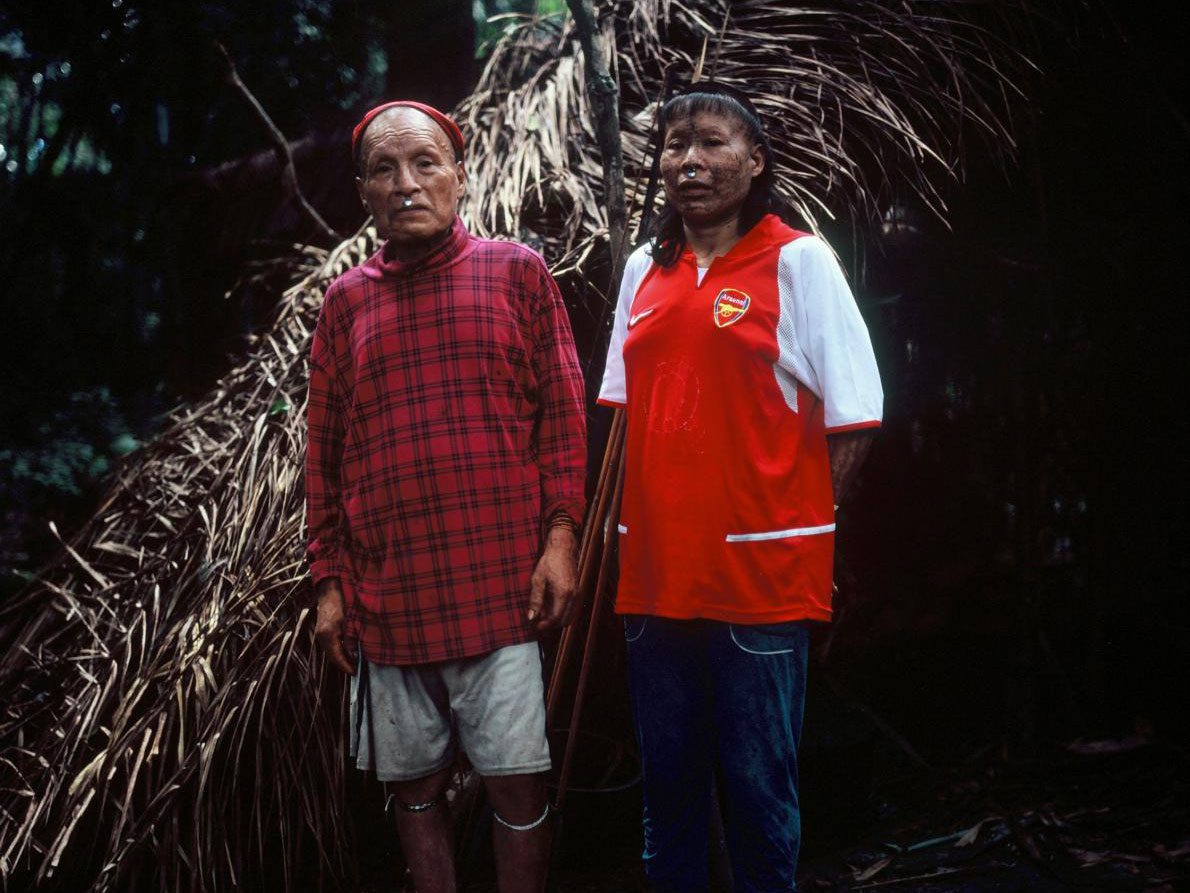 Shuri and wife Janet stand in front of their palm-thatched shelter, or maloca, in May 2017