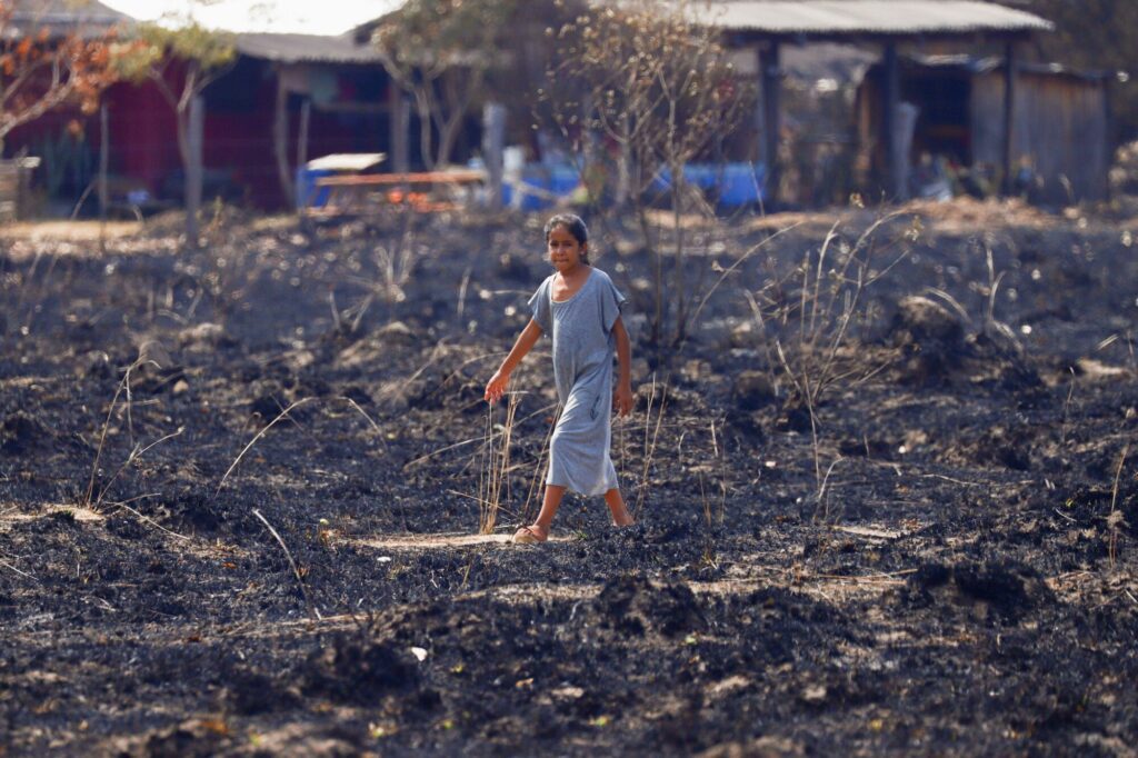 A girl walks through a pasture burnt by a wildfire, in a region hit by drought and high temperatures, near Santo Tome, province of Corrientes, Argentina February 21, 2022
